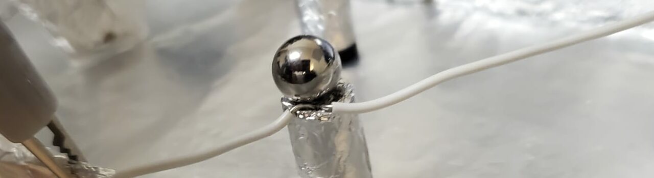 metallic ball on a little metallic pole, with wires coming out of the pole